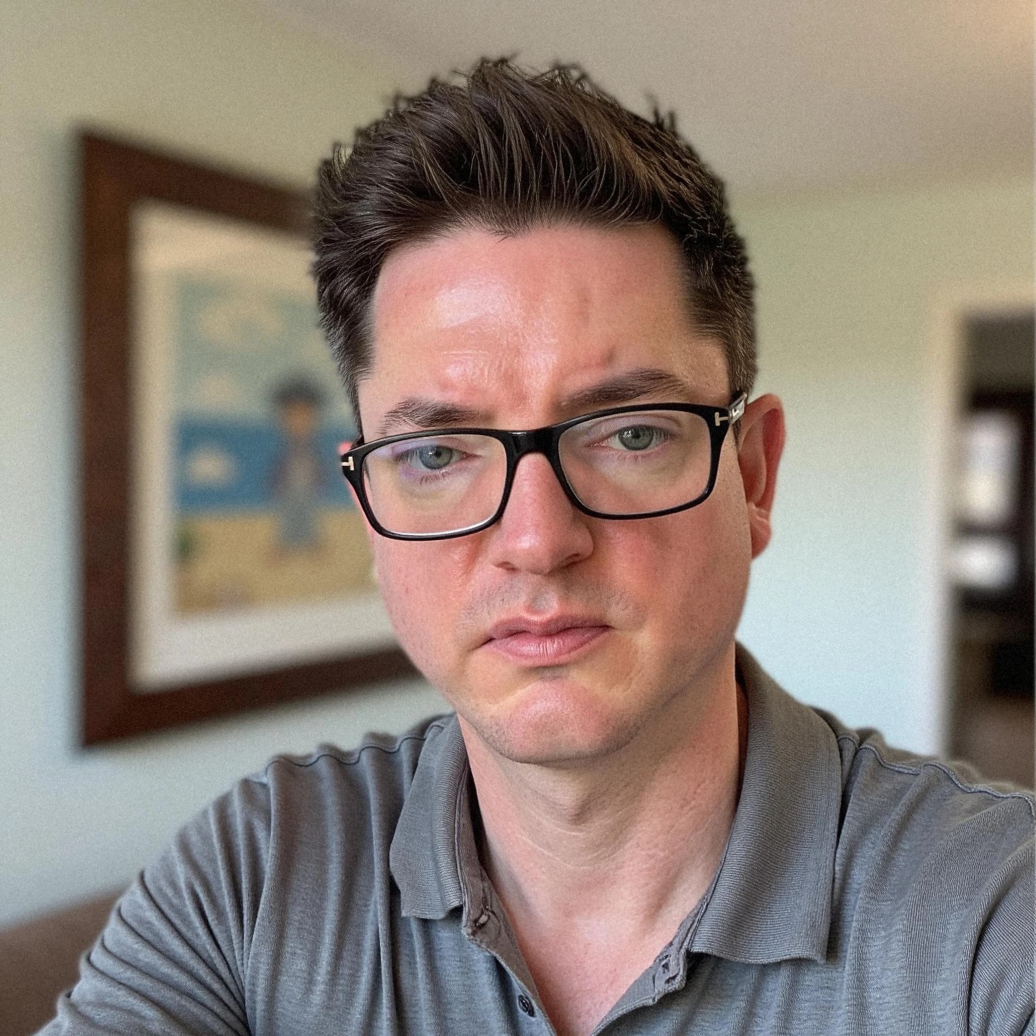 Professional headshot example: Man Home Grey Shirt Selfie — LinkedInHeadshots.ai