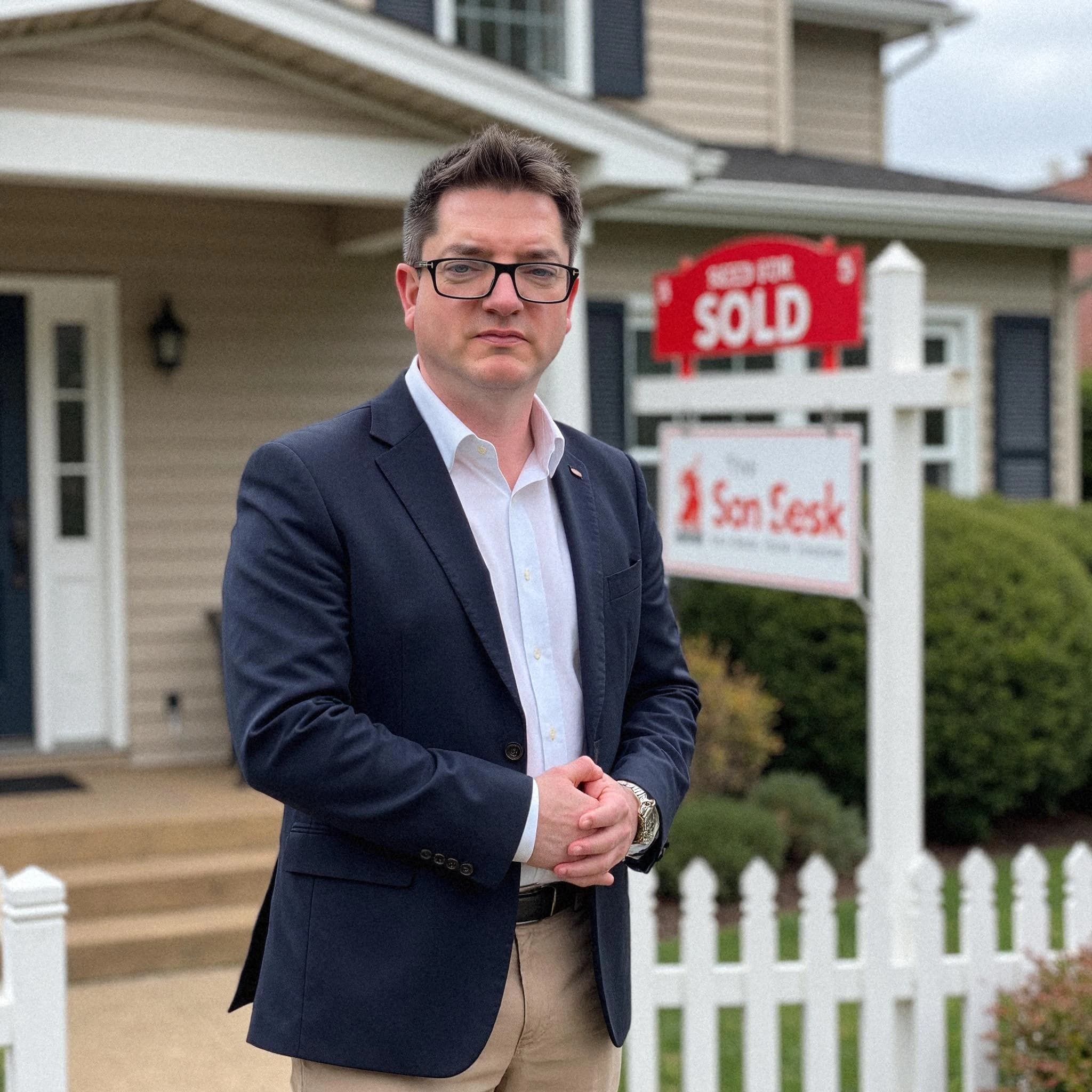 Professional headshot example: Man House Suit Standing Sold Sign — LinkedInHeadshots.ai