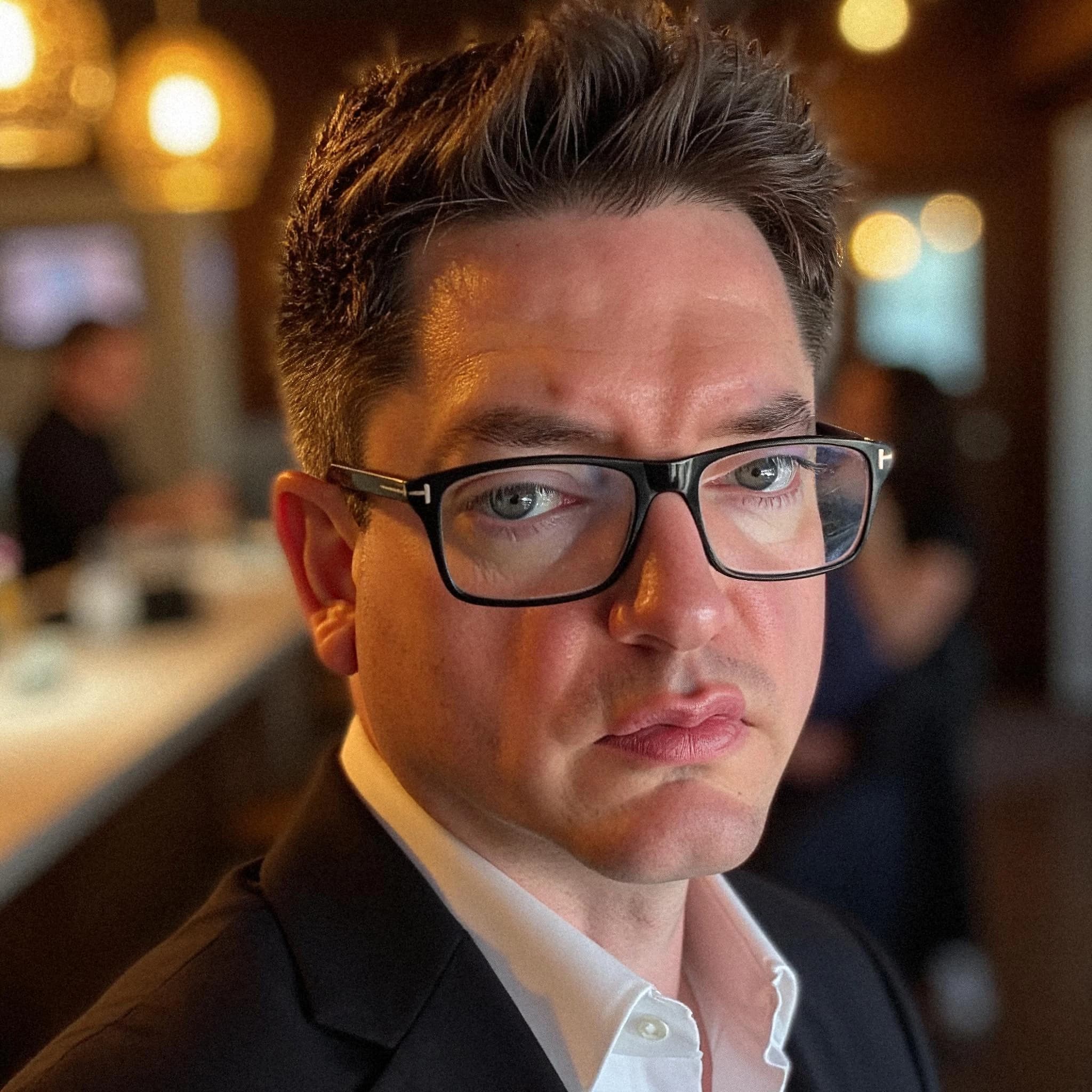 Professional headshot example: Man Indoor Black Suit Glasses — LinkedInHeadshots.ai