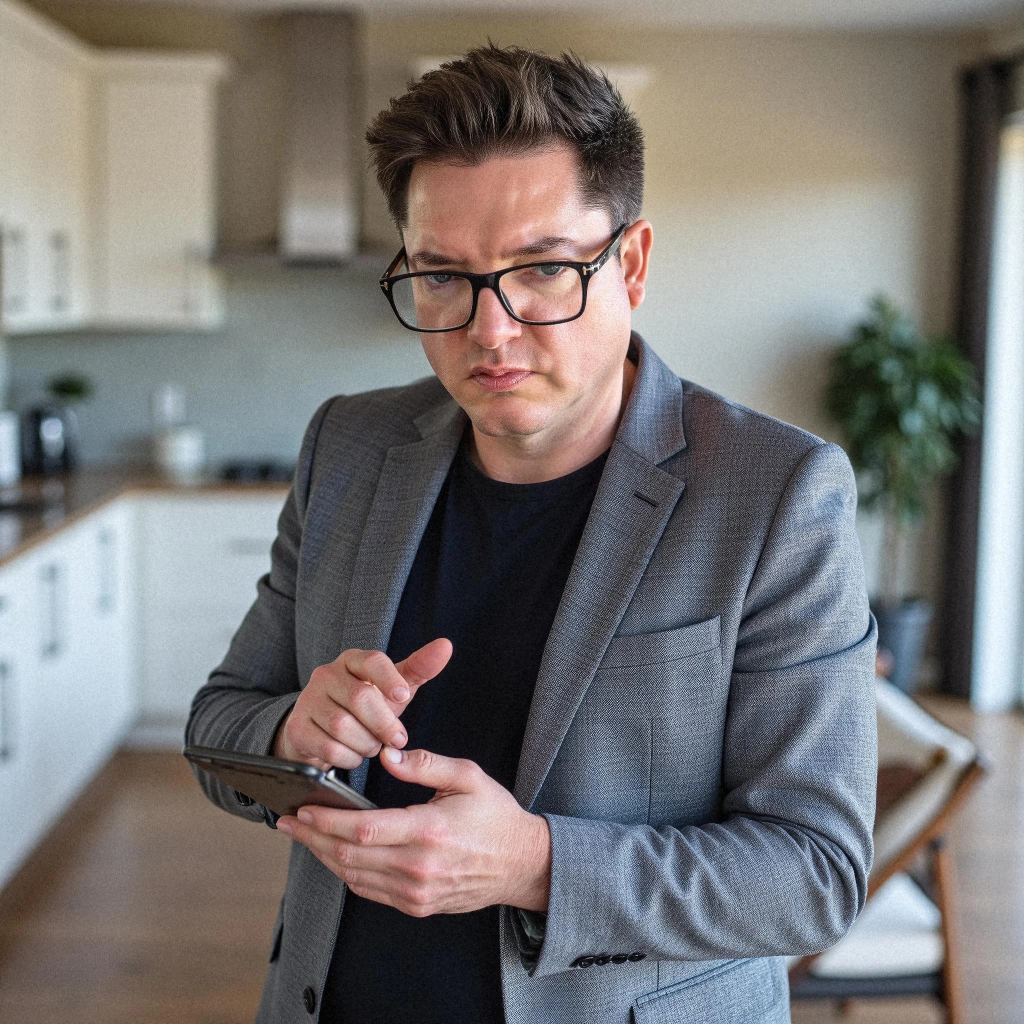 Professional headshot example: Man Kitchen Gray Blazer Using Phone — LinkedInHeadshots.ai