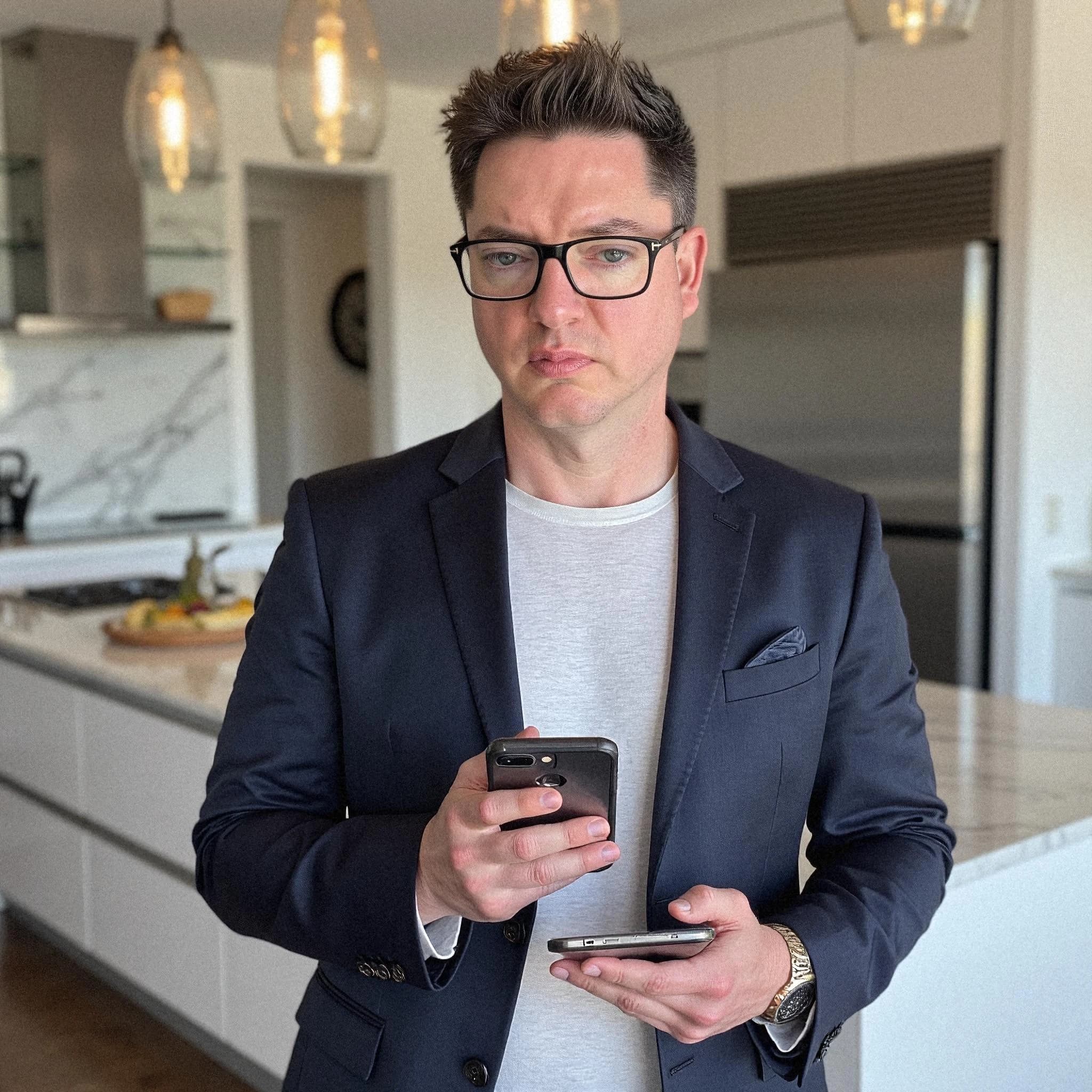 Professional headshot example: Man Kitchen Suit Holding Phones — LinkedInHeadshots.ai