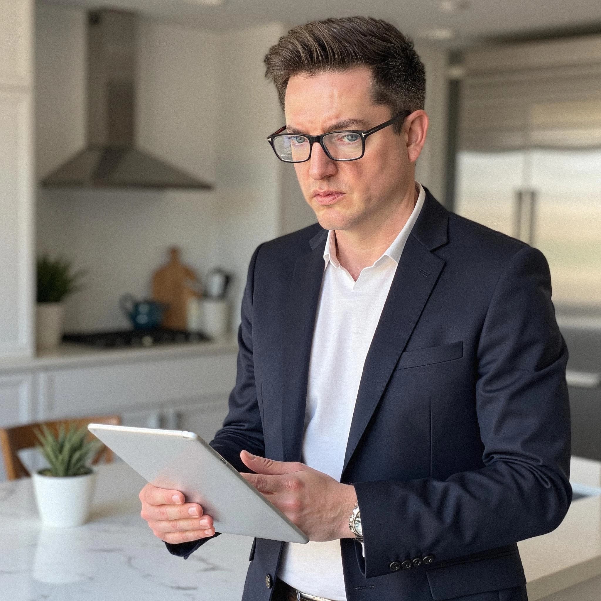 Professional headshot example: Man Kitchen Suit Holding Tablet 2 — LinkedInHeadshots.ai