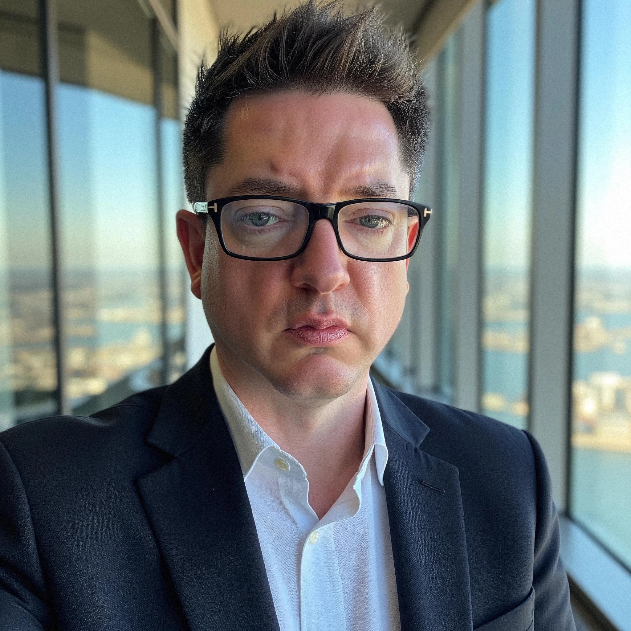 Professional headshot example: Man Office Suit Glasses Serious 6 — LinkedInHeadshots.ai
