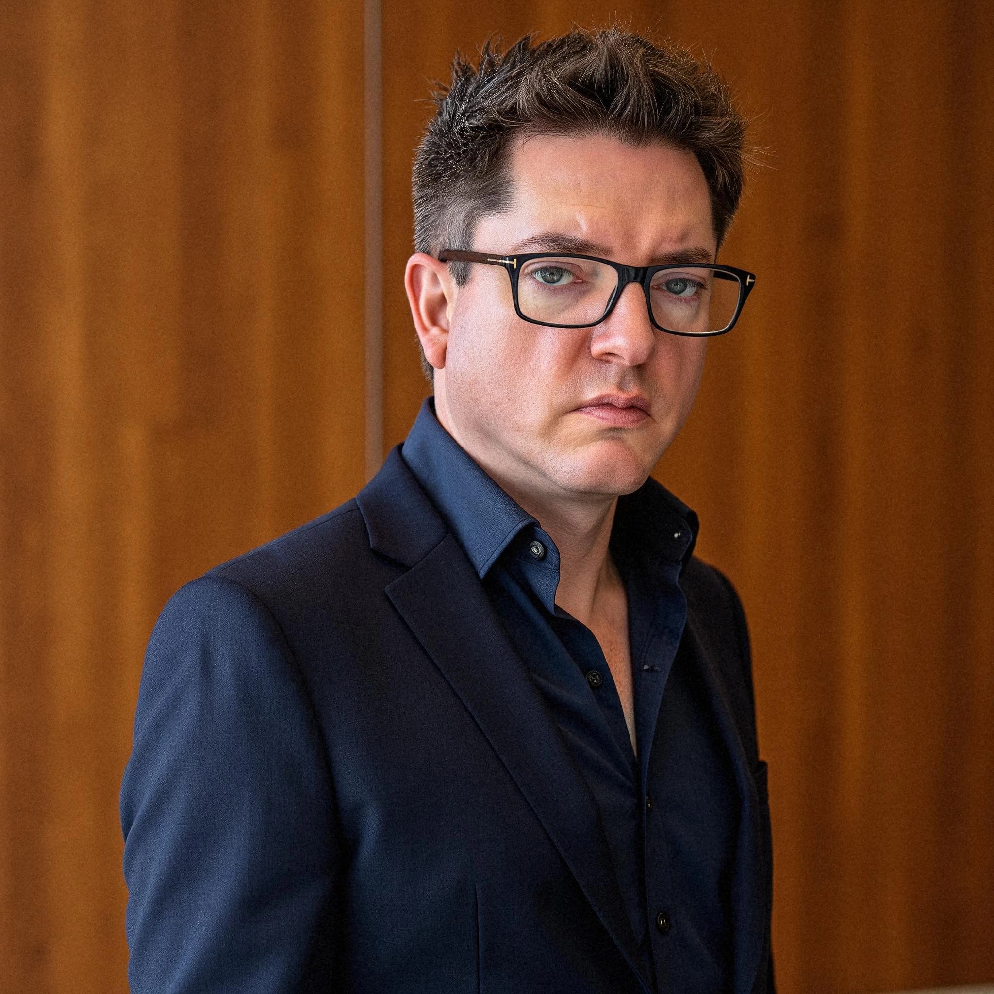 Professional headshot example: Man Office Suit Glasses Standing 3 — LinkedInHeadshots.ai