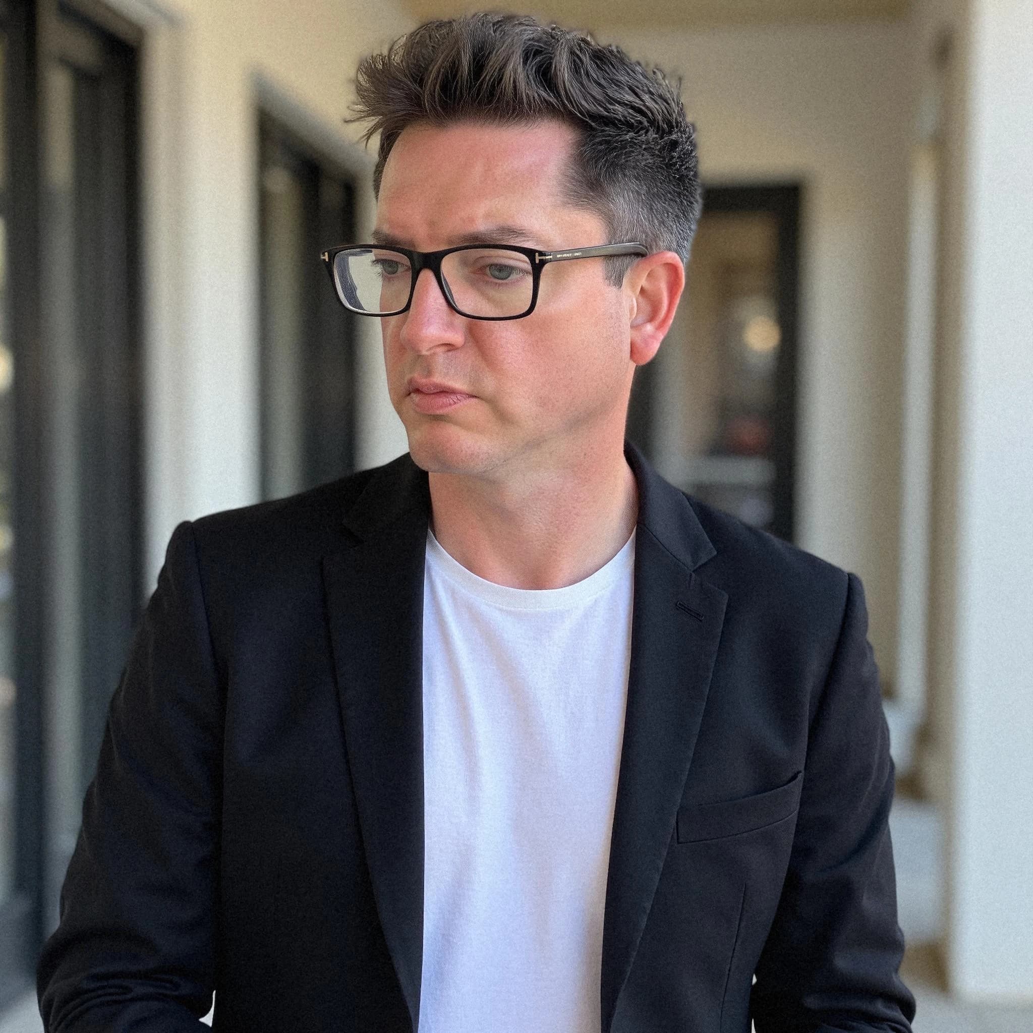 Professional headshot example: Man Outdoor Black Jacket Glasses — LinkedInHeadshots.ai