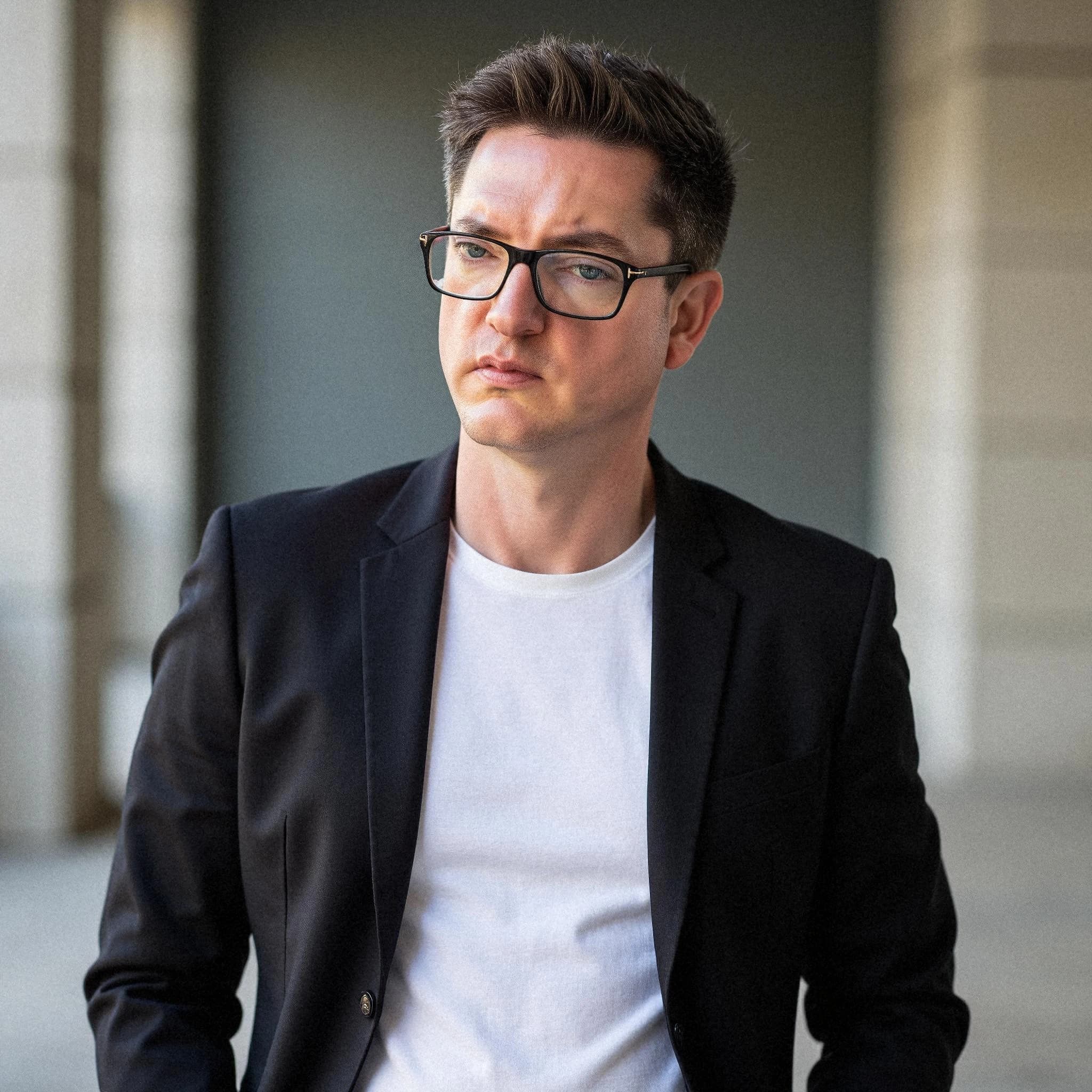 Professional headshot example: Man Outdoors Black Jacket Glasses 2 — LinkedInHeadshots.ai