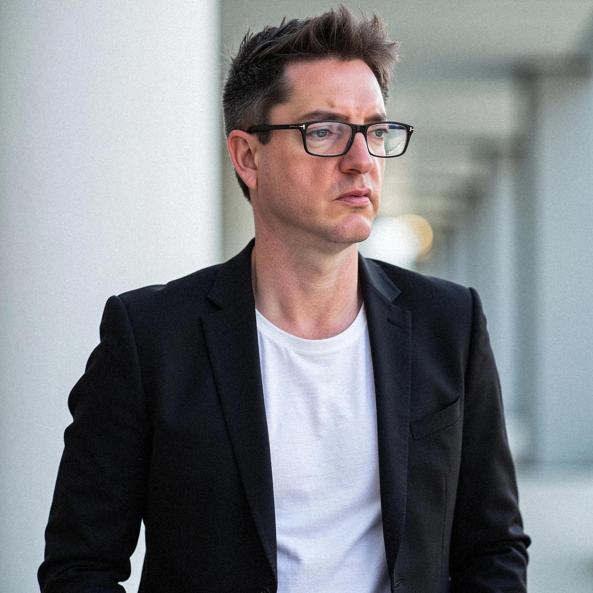 Professional headshot example: Man Outdoors Black Jacket Glasses 3 — LinkedInHeadshots.ai