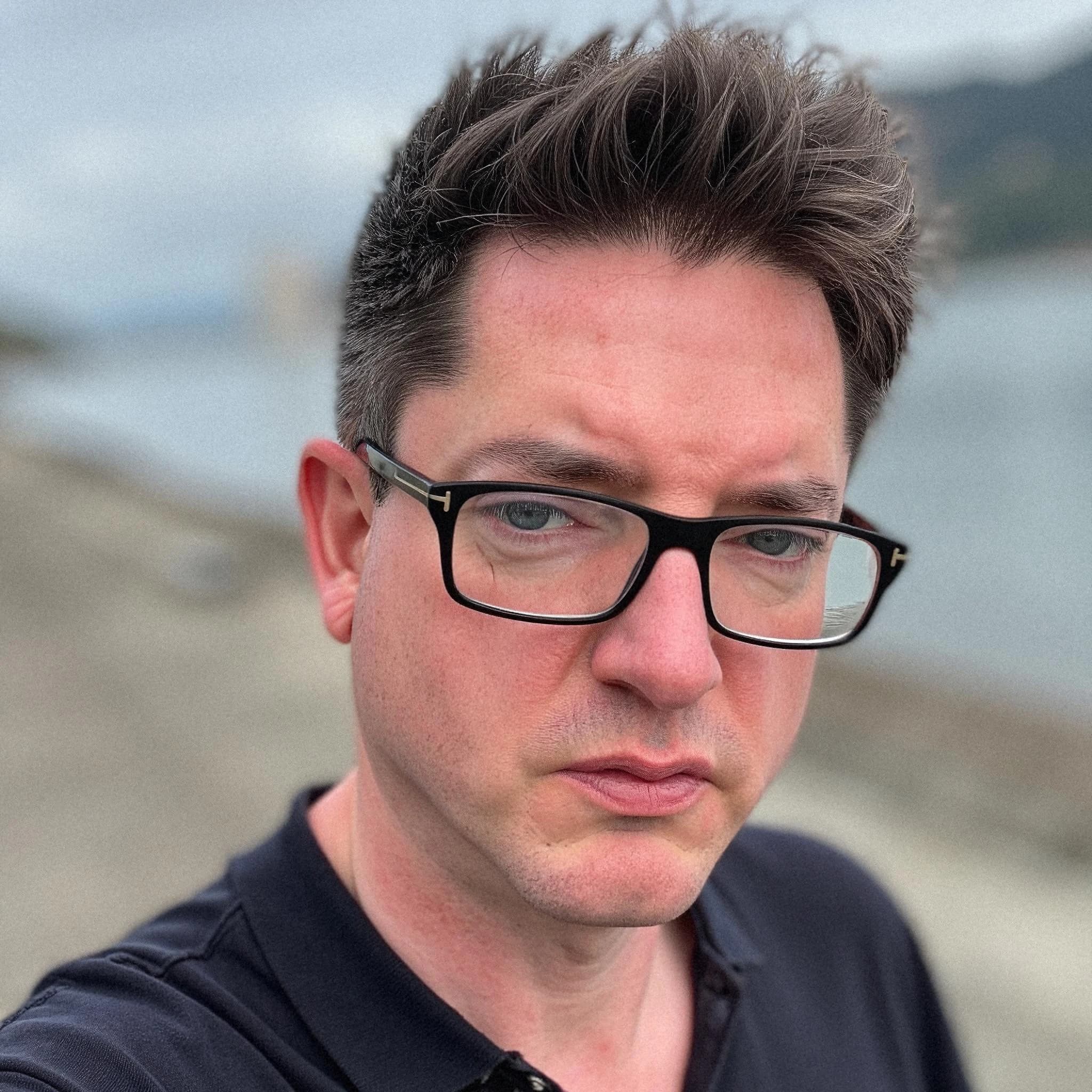 Professional headshot example: Man Outdoors Black Shirt Glasses 2 — LinkedInHeadshots.ai
