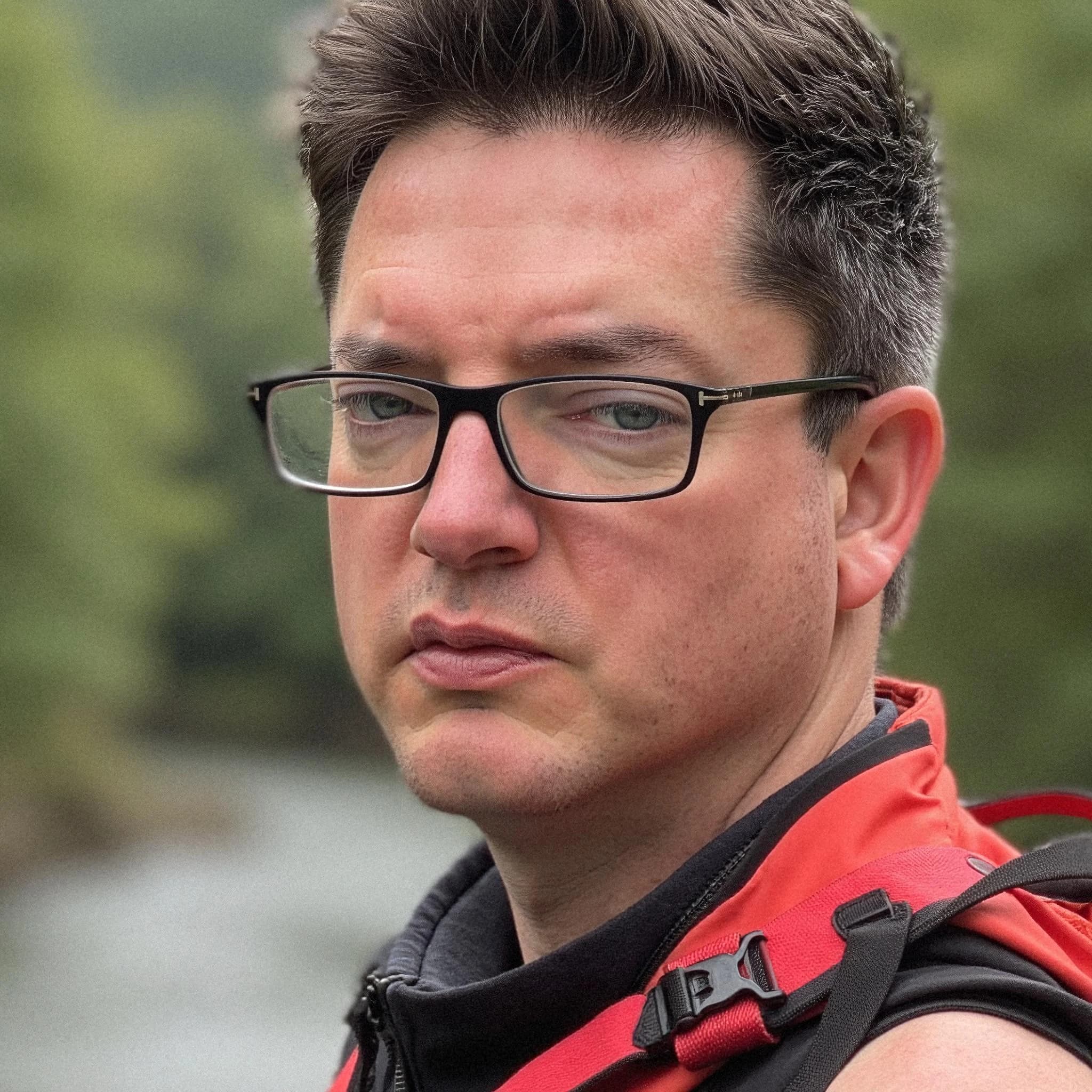 Professional headshot example: Man Outdoors Red Jacket Glasses — LinkedInHeadshots.ai