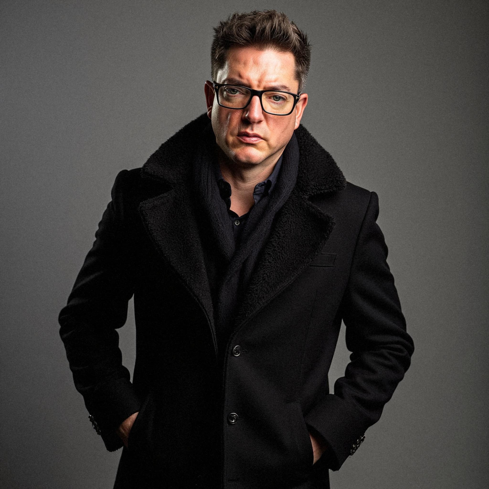 Professional headshot example: Man Studio Black Coat Standing 2 — LinkedInHeadshots.ai