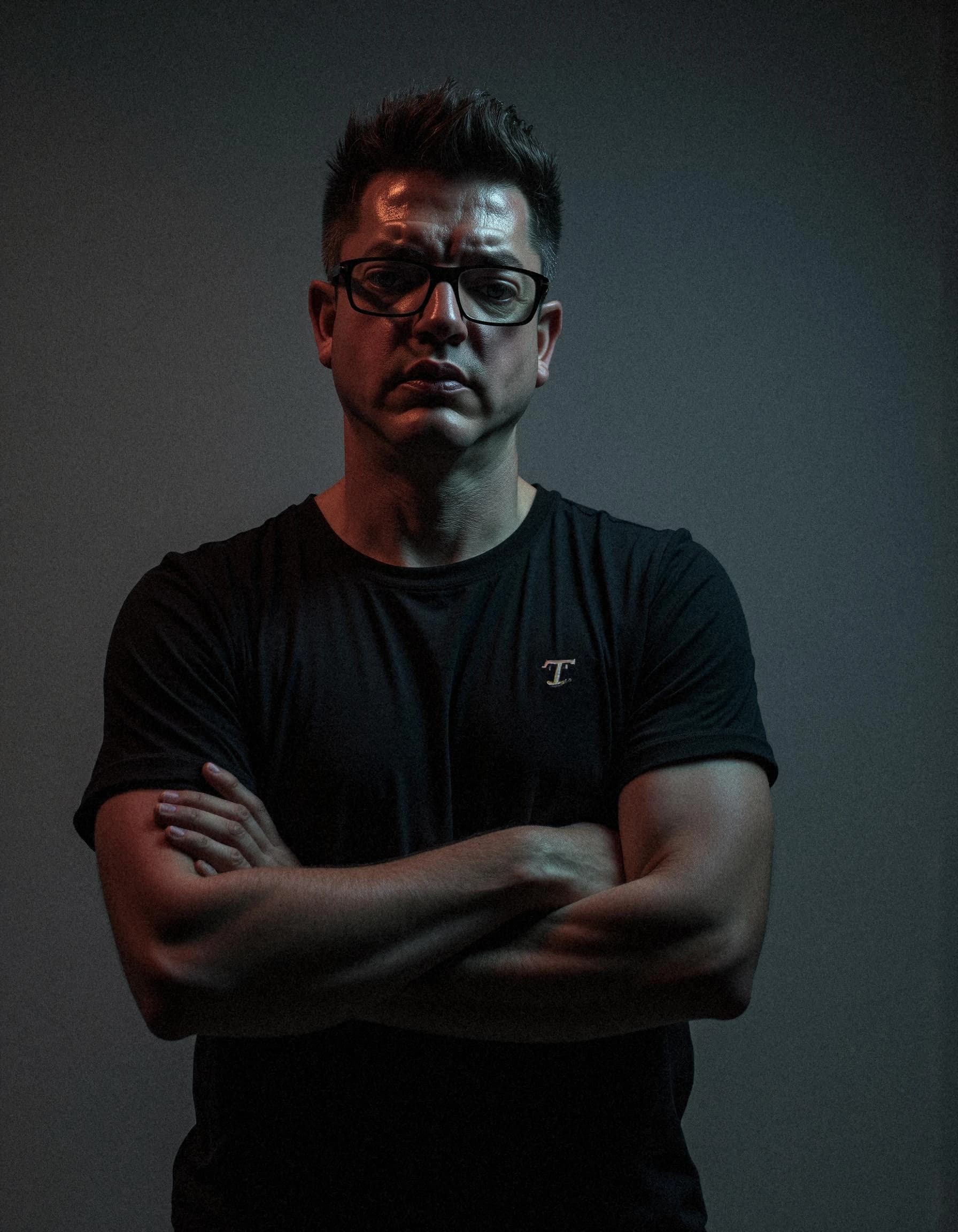 Professional headshot example: Man Studio Black Shirt Crossed Arms 2 — LinkedInHeadshots.ai