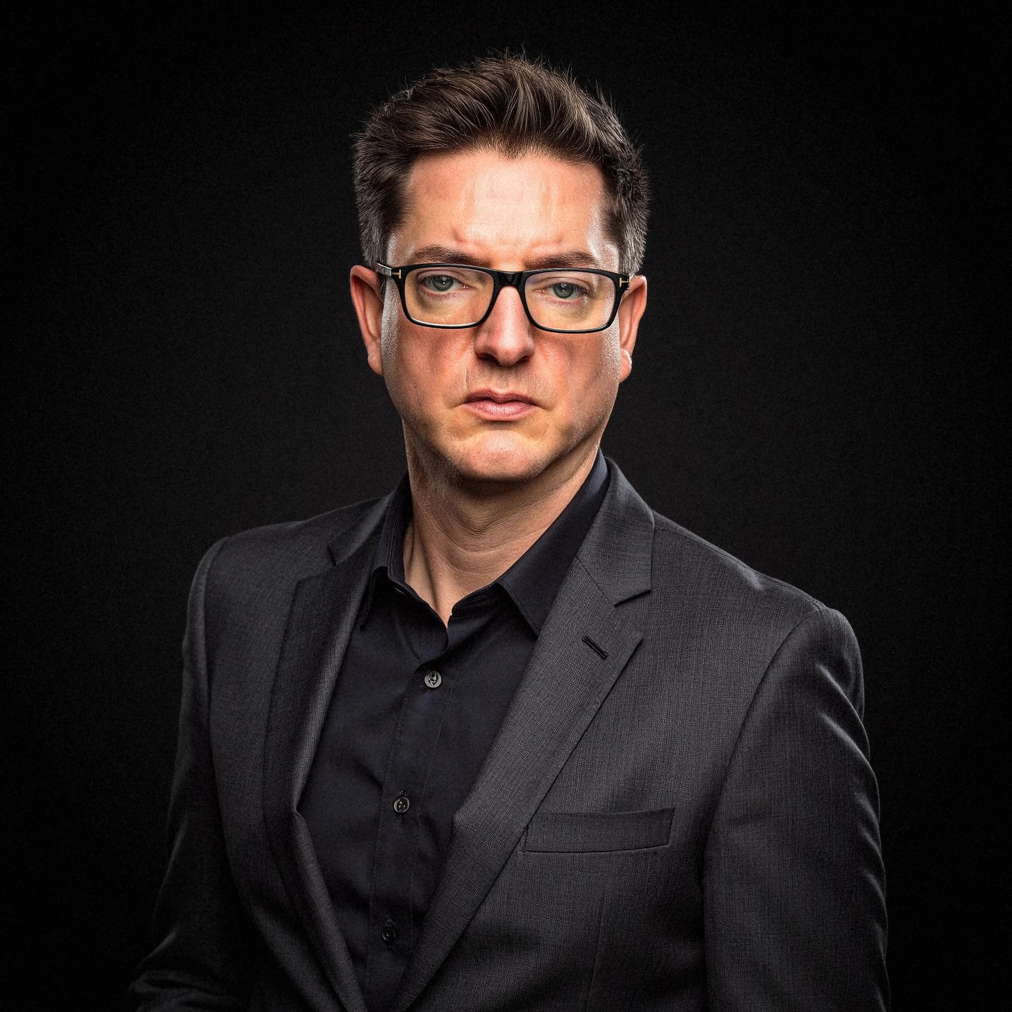 Professional headshot example: Man Studio Black Suit Serious — LinkedInHeadshots.ai