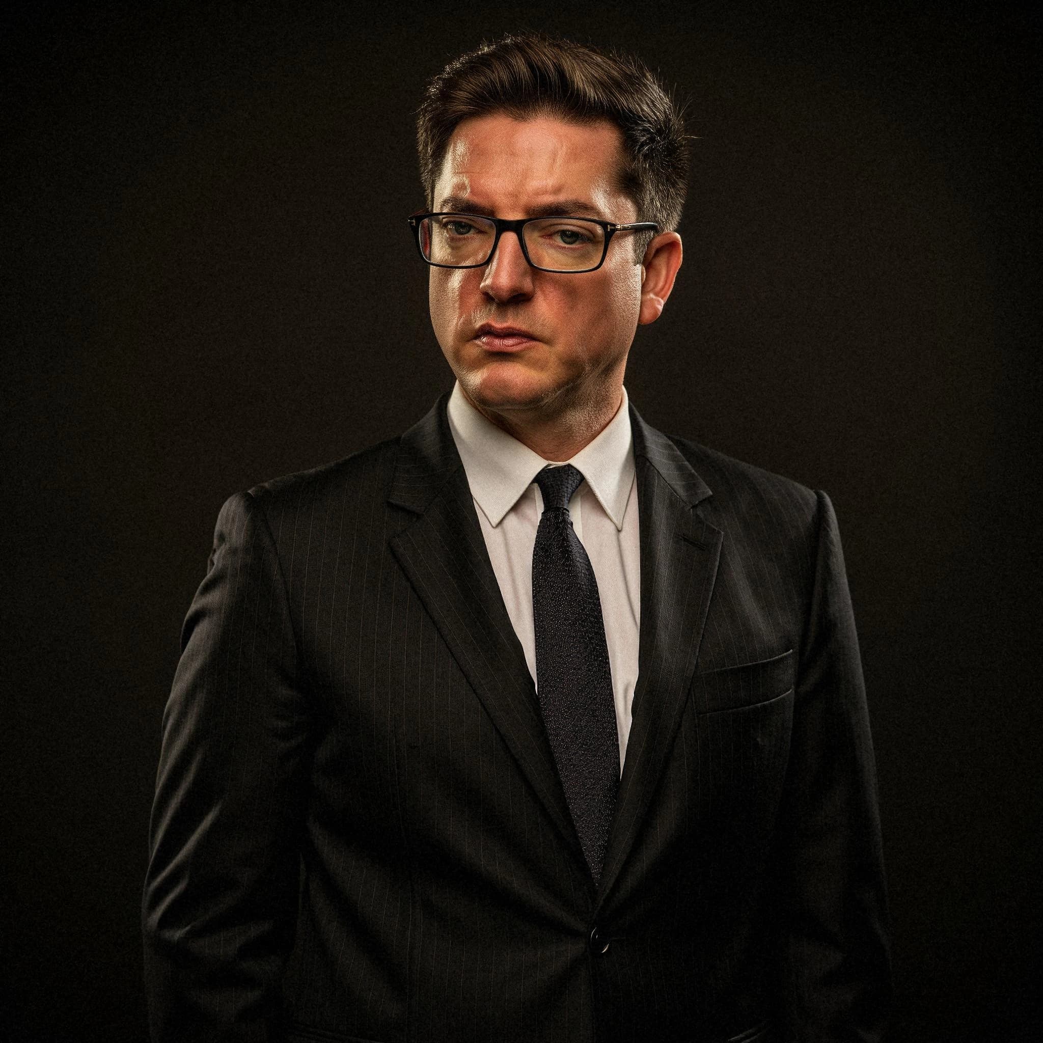 Professional headshot example: Man Studio Black Suit Serious 2 — LinkedInHeadshots.ai