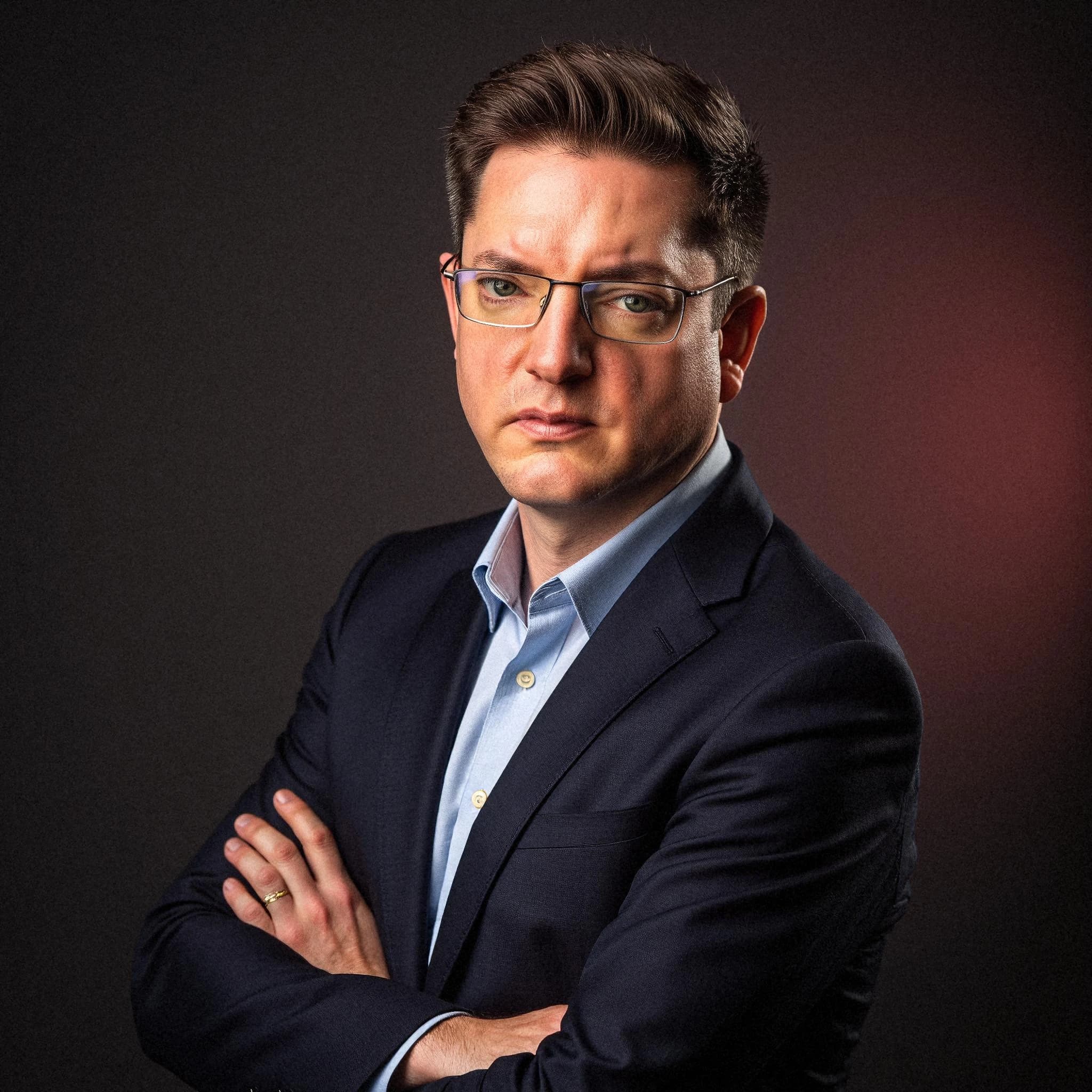 Professional headshot example: Man Studio Suit Crossed Arms 7 — LinkedInHeadshots.ai