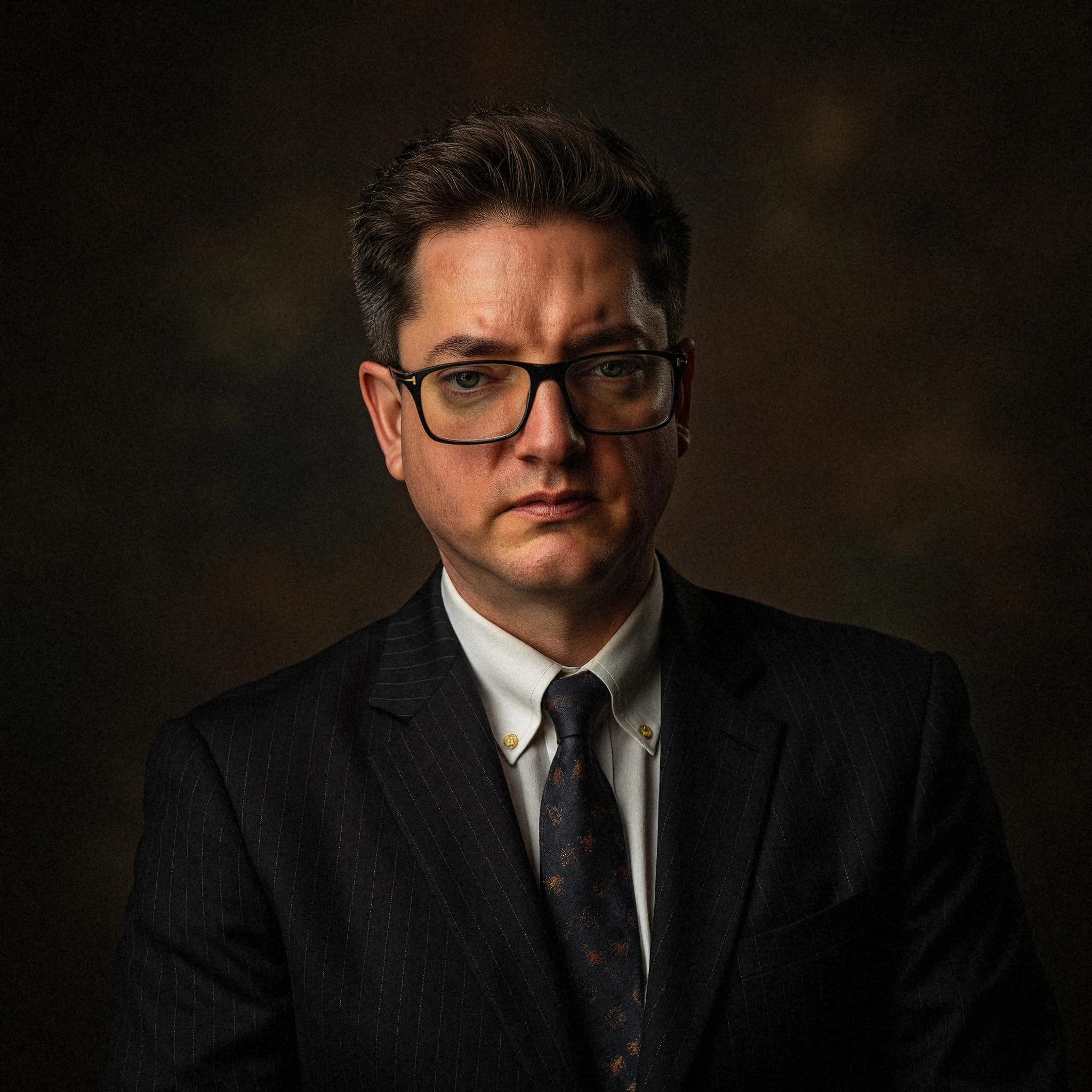 Professional headshot example: Man Studio Suit Glasses Portrait 2 — LinkedInHeadshots.ai