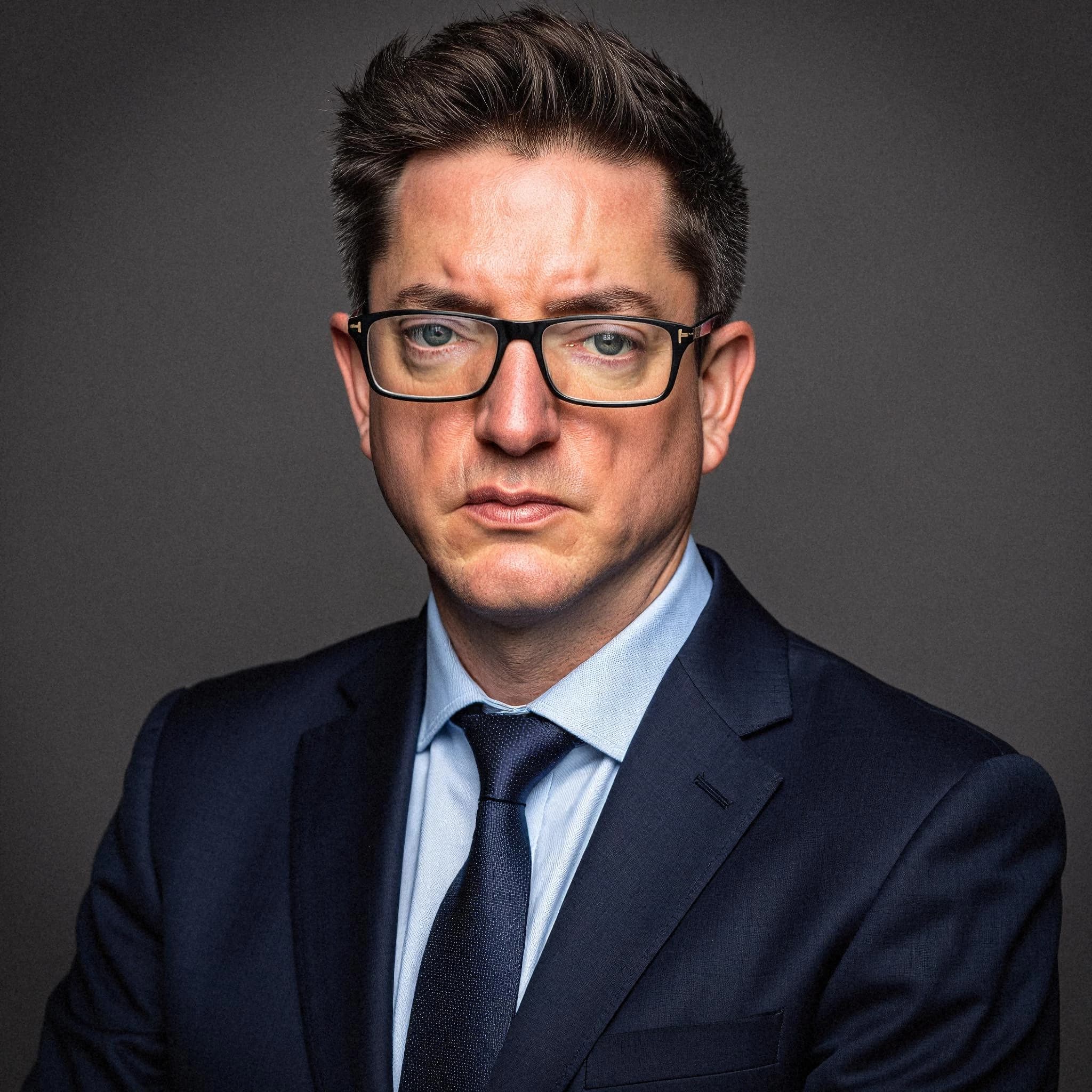 Professional headshot example: Man Studio Suit Glasses Serious 12 — LinkedInHeadshots.ai