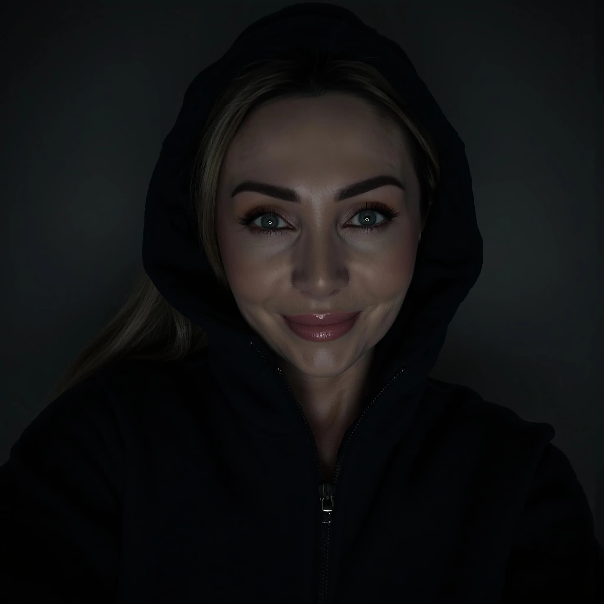 Professional headshot example: Woman Dark Hoodie Smiling Closeup — LinkedInHeadshots.ai