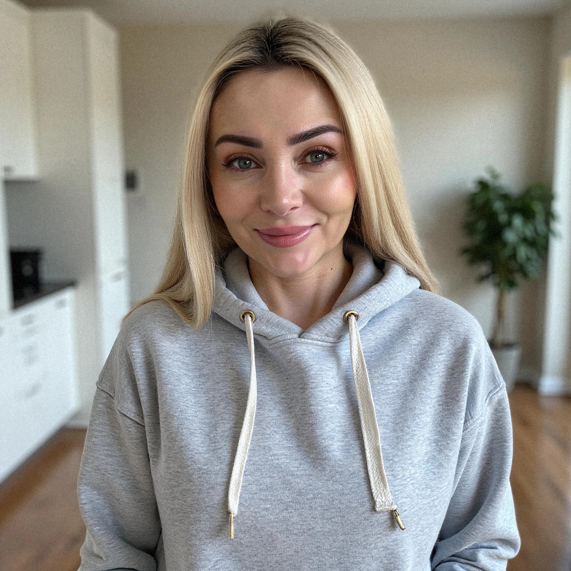 Professional headshot example: Woman Home Gray Hoodie Smiling — LinkedInHeadshots.ai