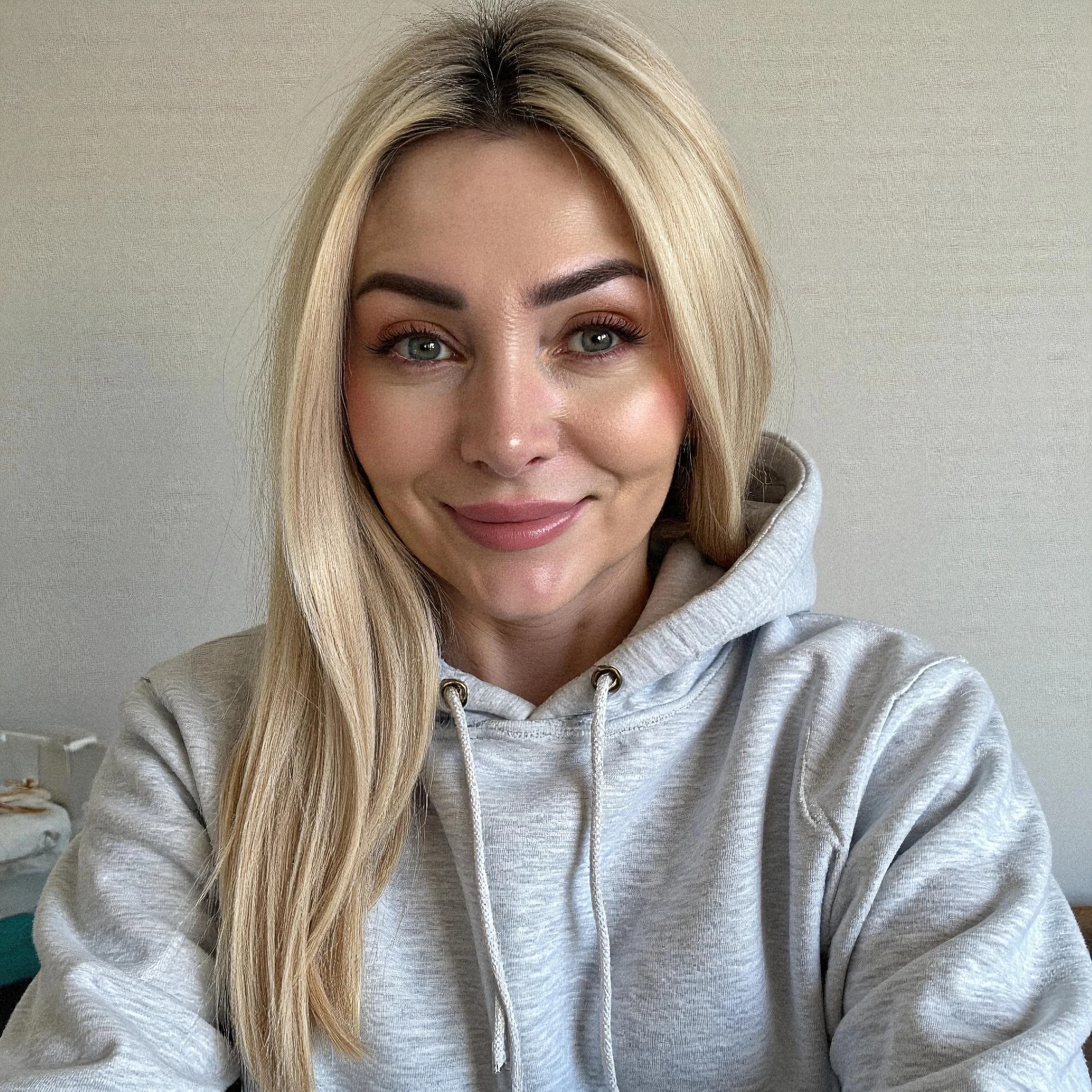 Professional headshot example: Woman Home Gray Hoodie Smiling 2 — LinkedInHeadshots.ai