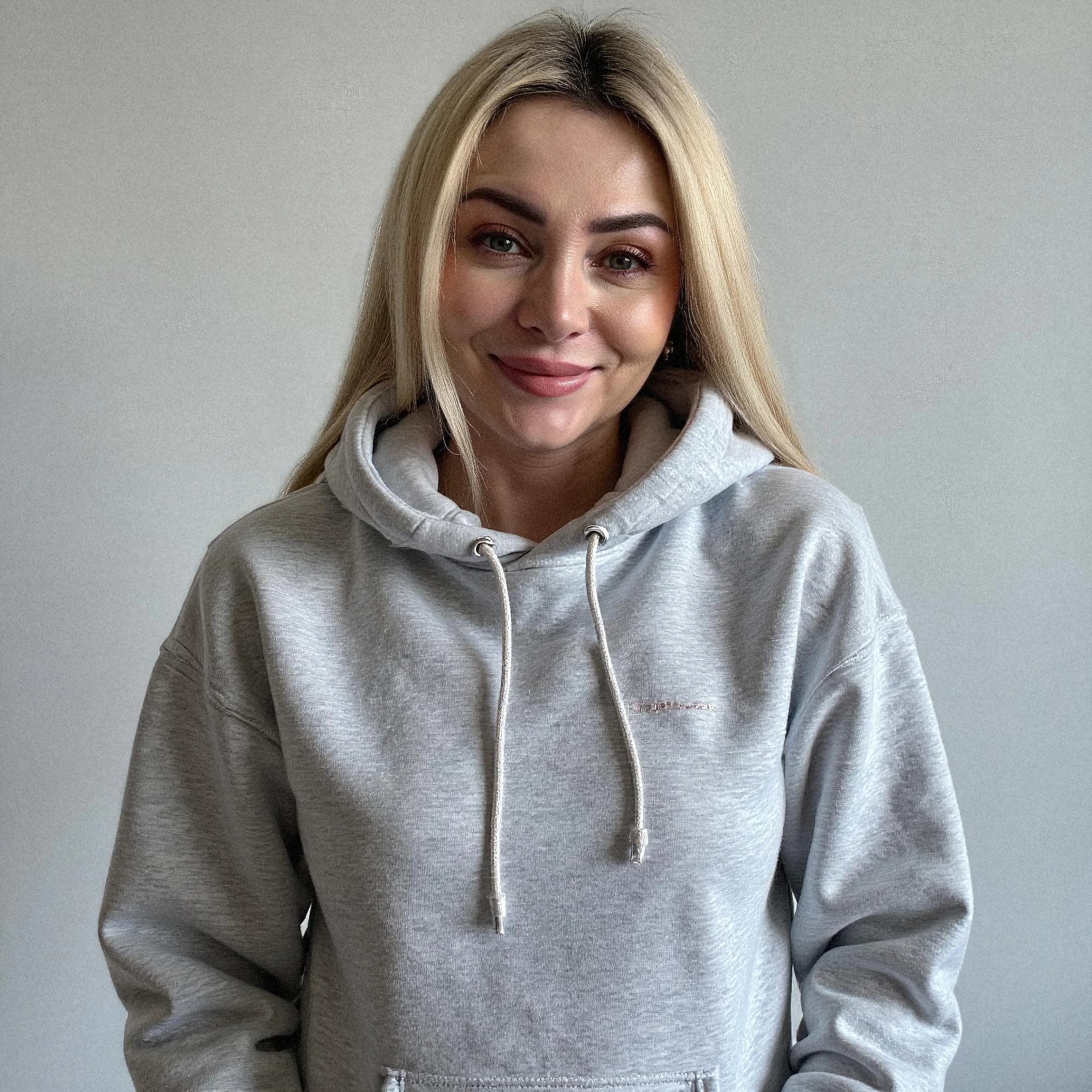 Professional headshot example: Woman Indoor Grey Hoodie Smiling — LinkedInHeadshots.ai