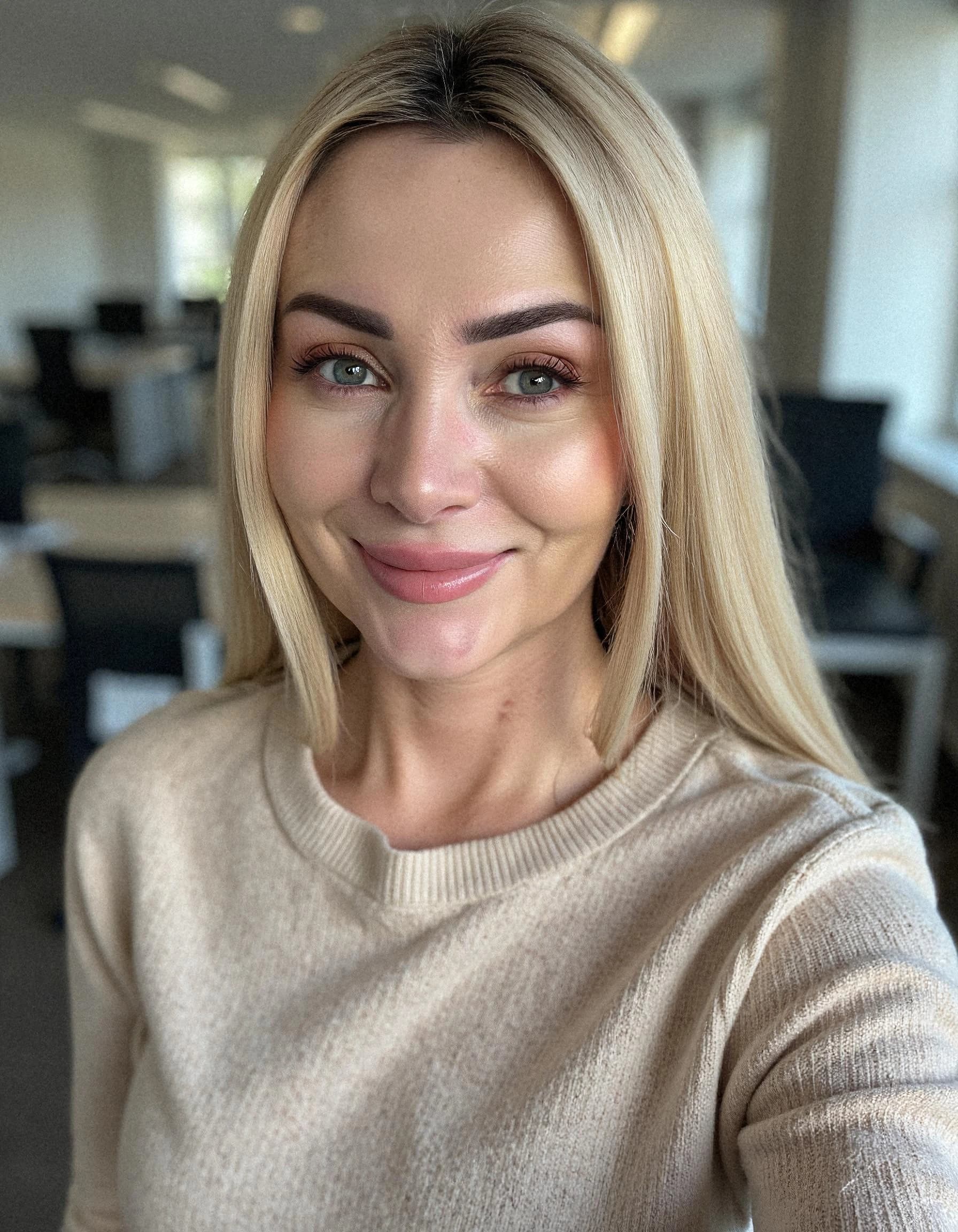Professional headshot example: Woman Office Beige Sweater Smiling — LinkedInHeadshots.ai