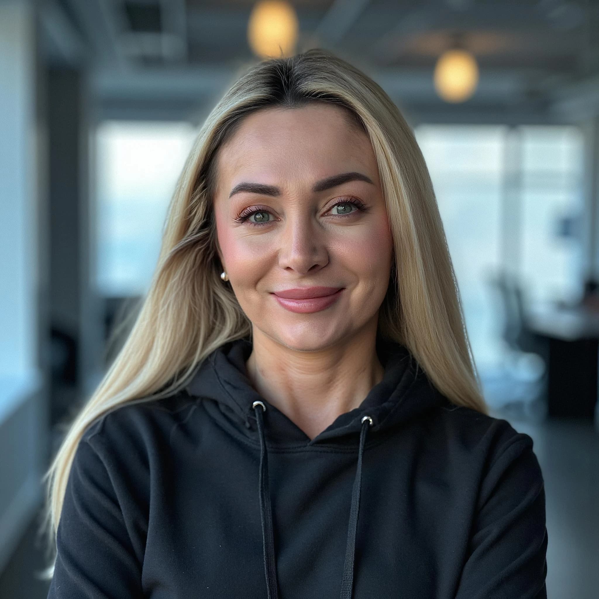 Professional headshot example: Woman Office Black Hoodie Smiling — LinkedInHeadshots.ai