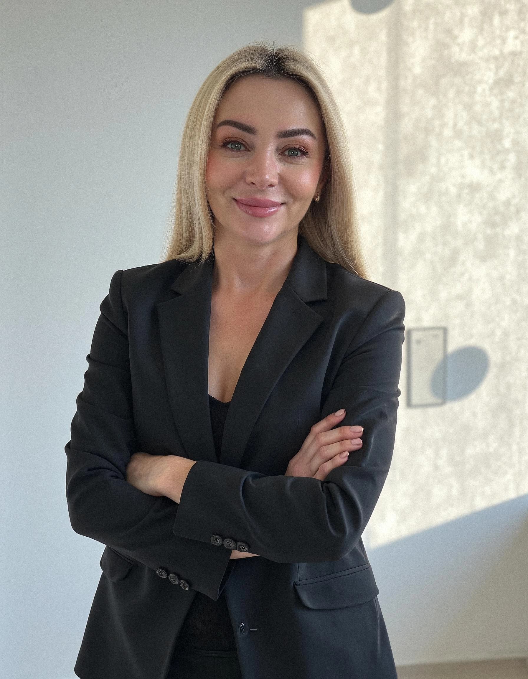 Professional headshot example: Woman Office Black Suit Crossed Arms — LinkedInHeadshots.ai