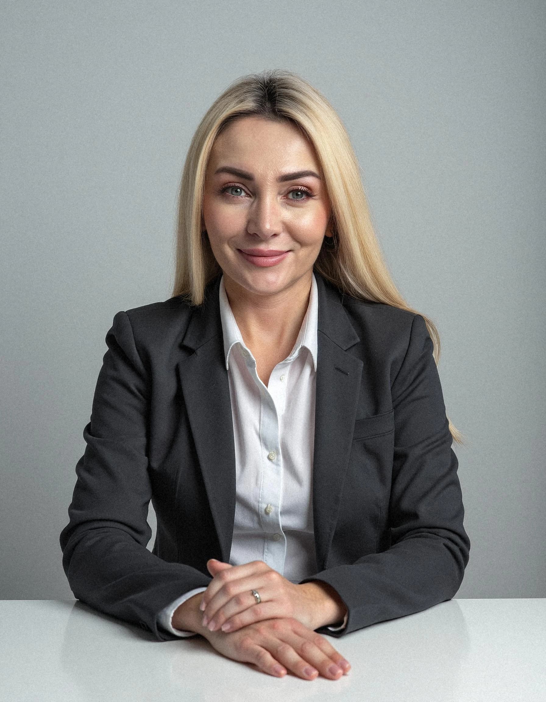 Professional headshot example: Woman Office Black Suit Sitting — LinkedInHeadshots.ai