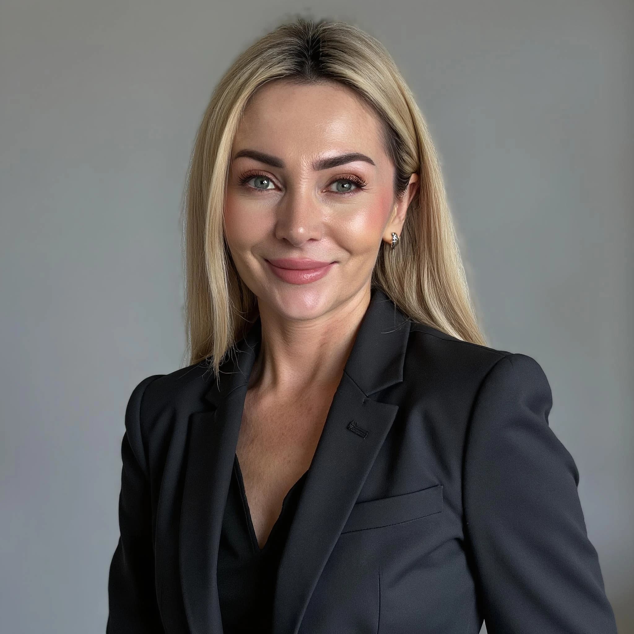 Professional headshot example: Woman Office Black Suit Smiling 2 — LinkedInHeadshots.ai