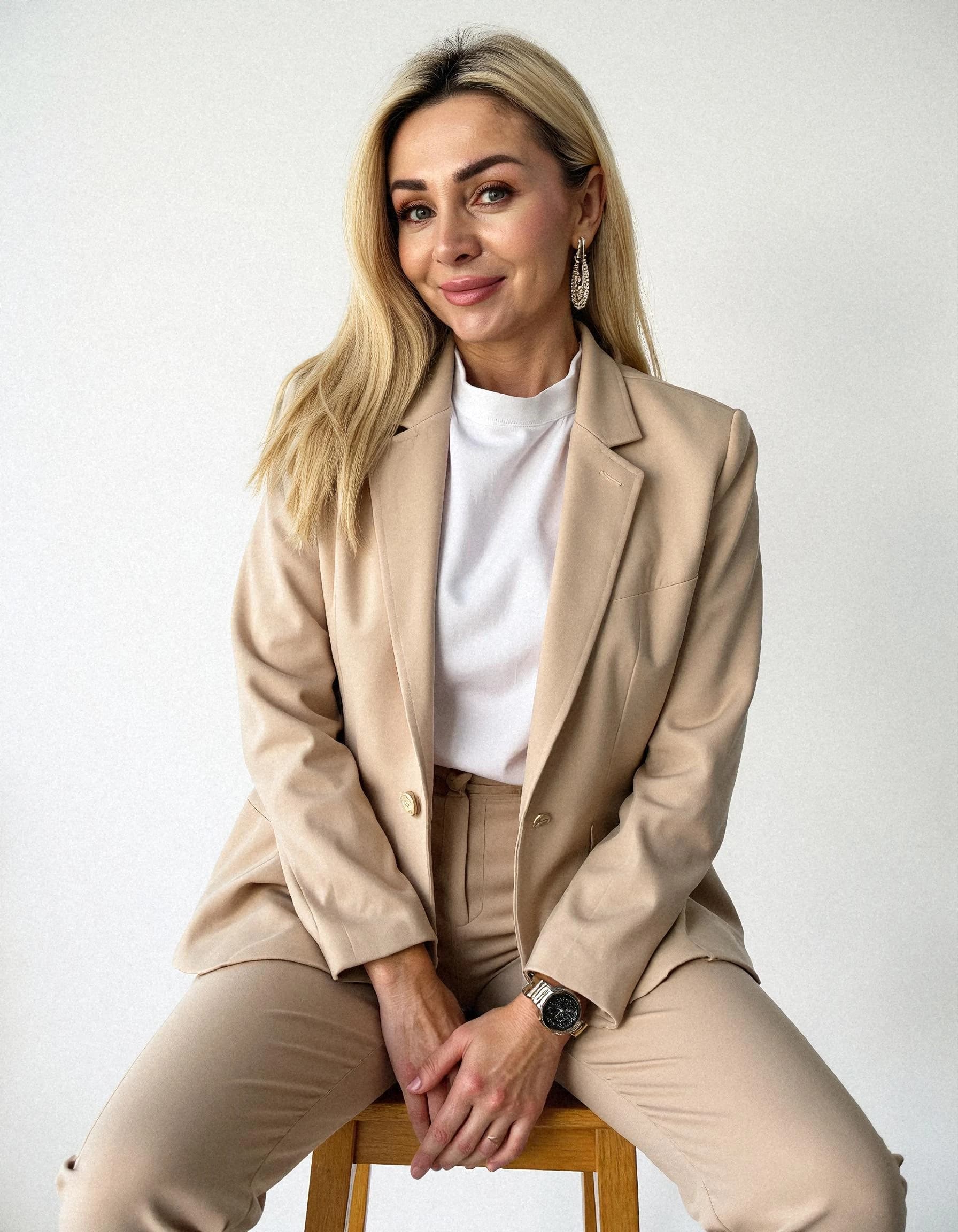 Professional headshot example: Woman Studio Beige Suit Sitting — LinkedInHeadshots.ai