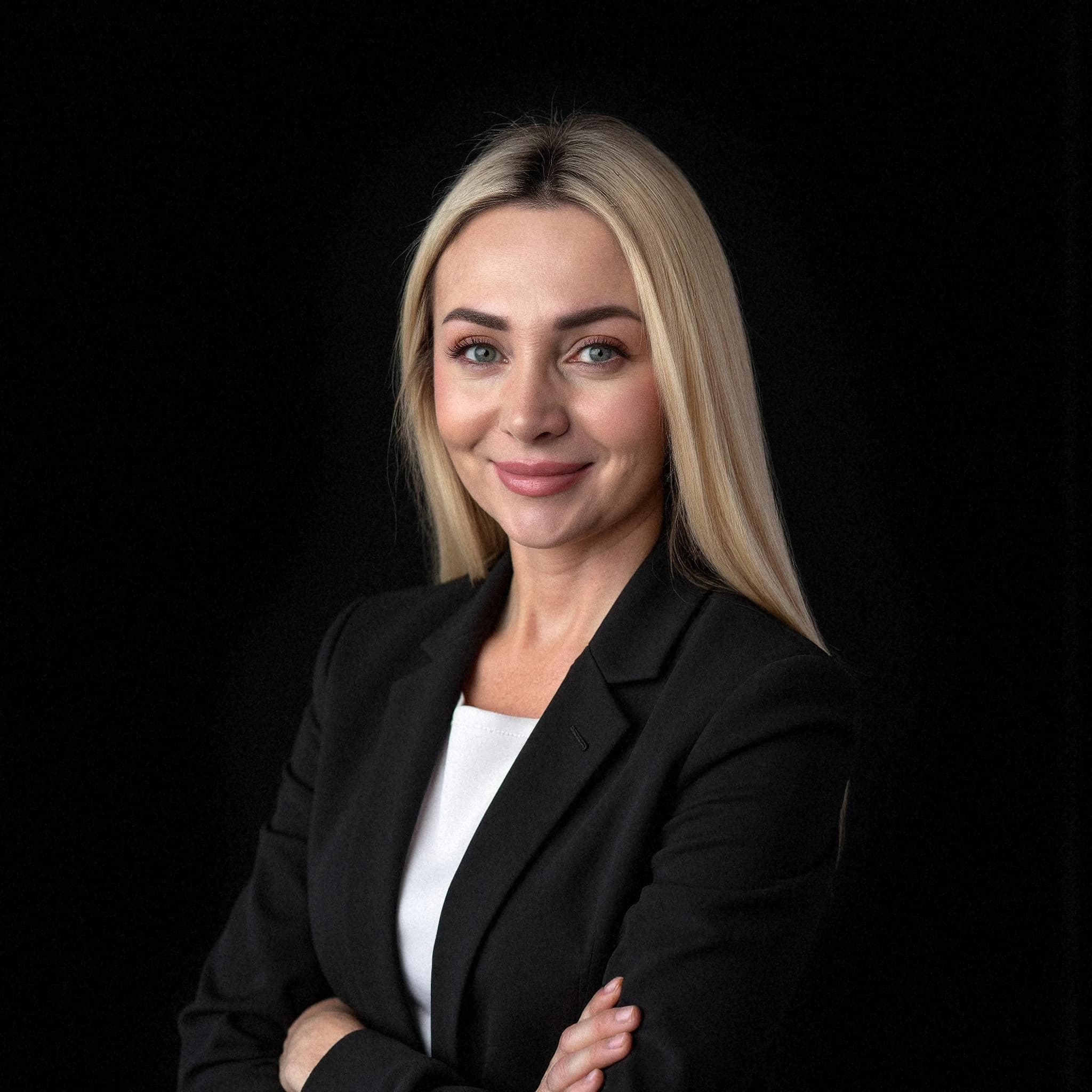 Professional headshot example: Woman Studio Black Suit Crossed Arms — LinkedInHeadshots.ai