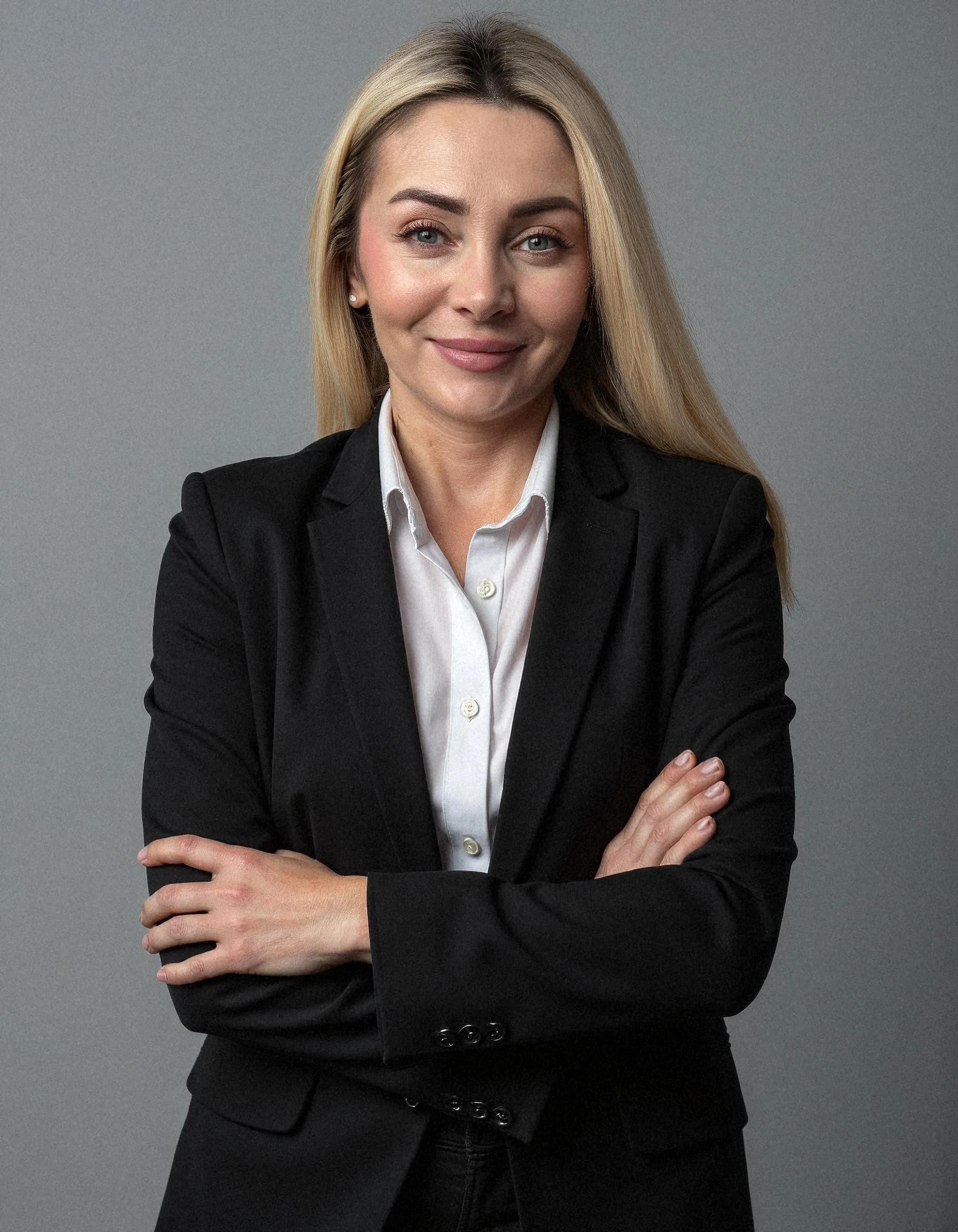 Professional headshot example: Woman Studio Black Suit Crossed Arms 4 — LinkedInHeadshots.ai