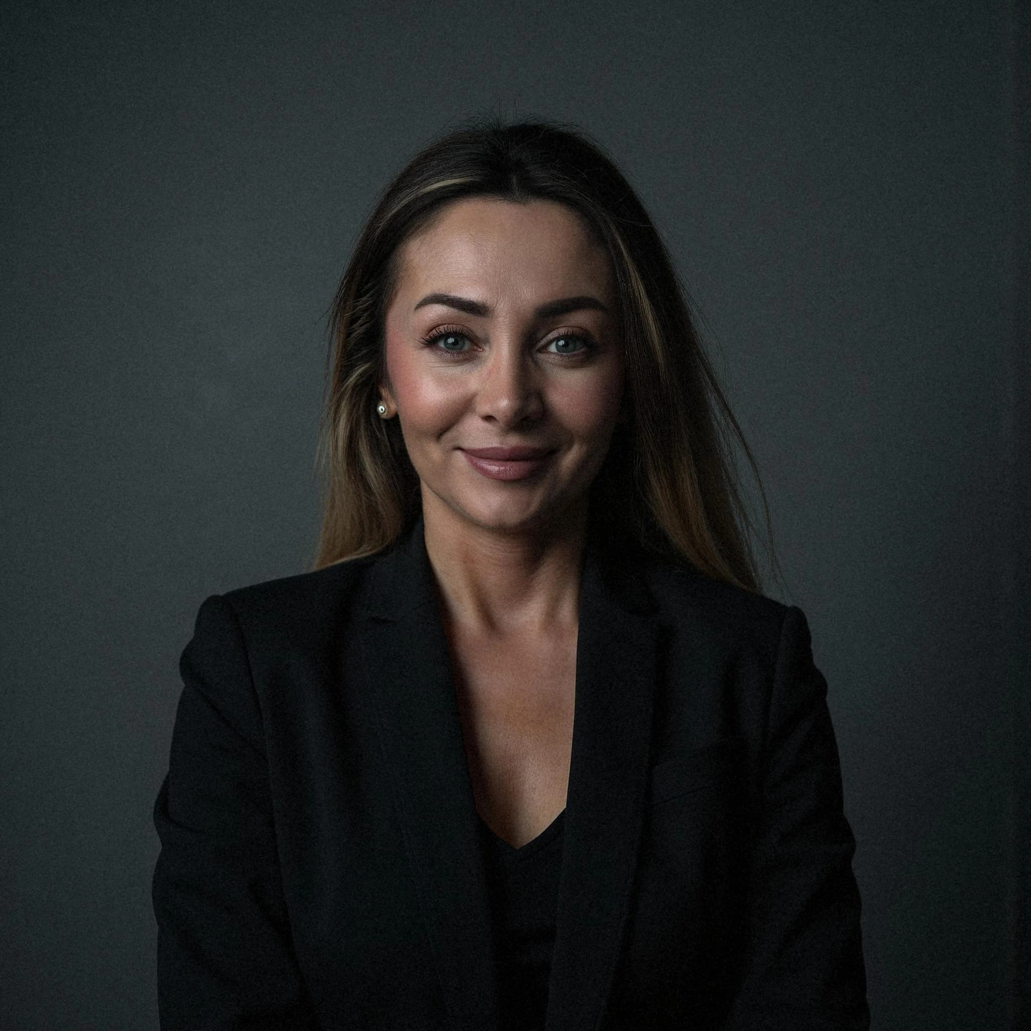 Professional headshot example: Woman Studio Black Suit Smiling 33 — LinkedInHeadshots.ai
