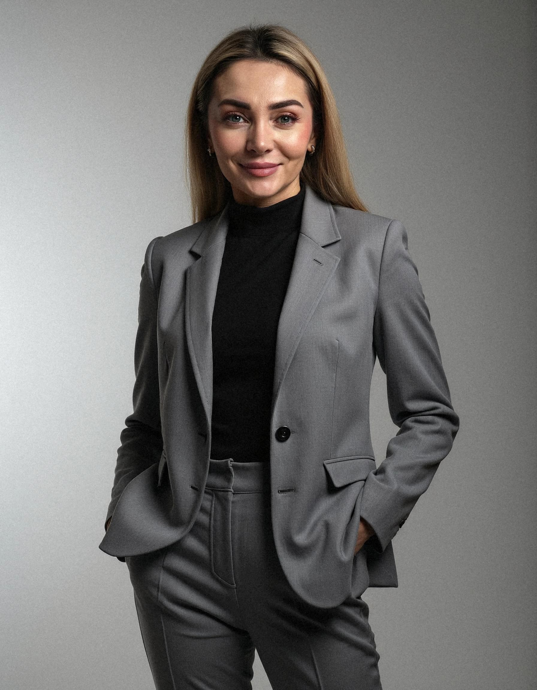 Professional headshot example: Woman Studio Gray Suit Smiling — LinkedInHeadshots.ai