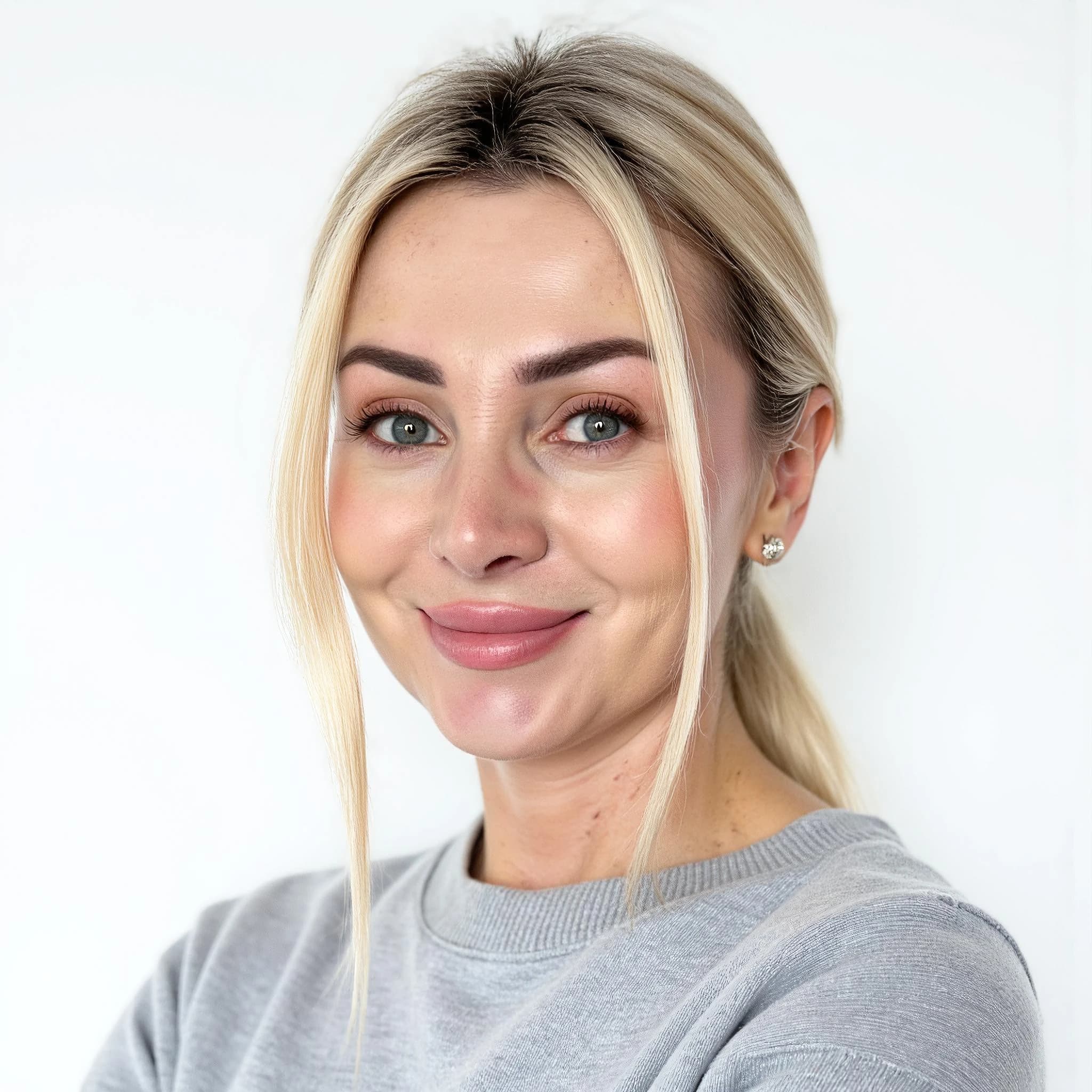 Professional headshot example: Woman Studio Grey Sweater Smiling — LinkedInHeadshots.ai