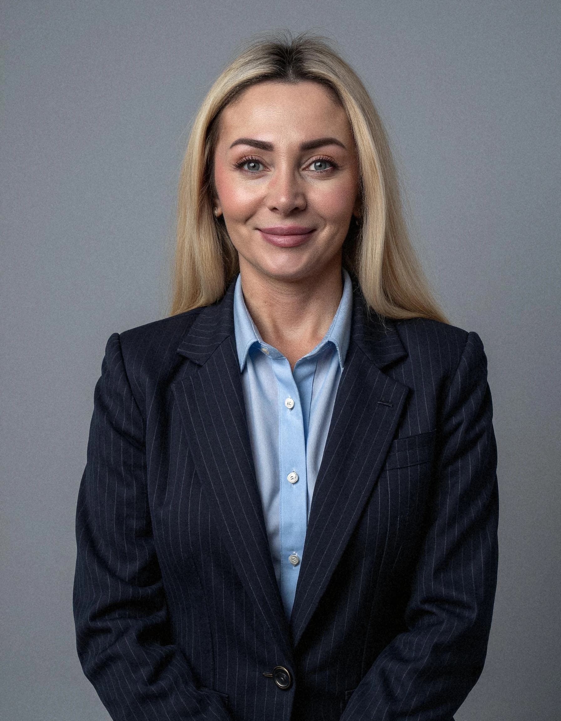 Professional headshot example: Woman Studio Navy Suit Smiling 2 — LinkedInHeadshots.ai