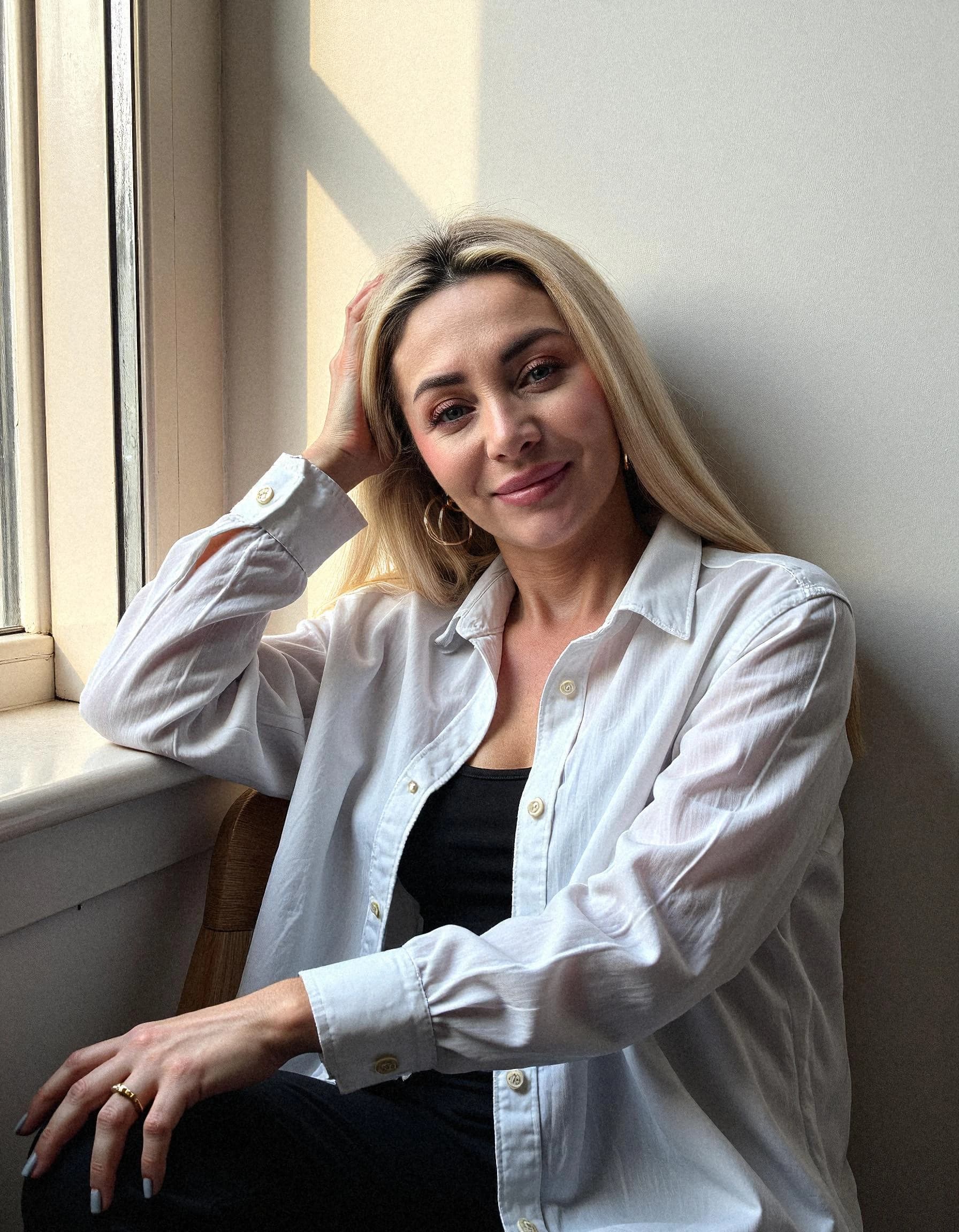 Professional headshot example: Woman Window White Shirt Smiling — LinkedInHeadshots.ai